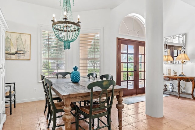 dining room featuring french doors, light tile patterned floors, and an inviting chandelier