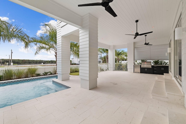 view of pool with an outdoor kitchen, a patio, and grilling area