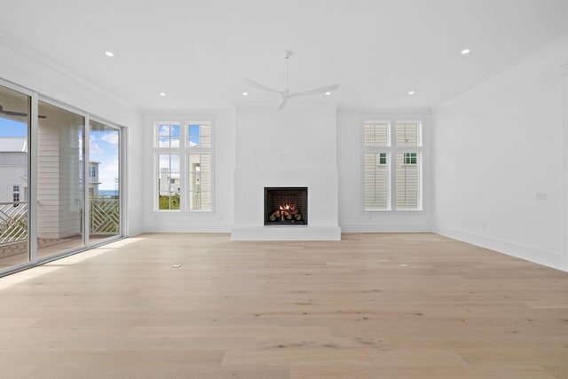 unfurnished living room with ceiling fan, light hardwood / wood-style floors, crown molding, and a wealth of natural light