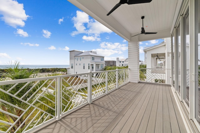 wooden deck with a water view and ceiling fan