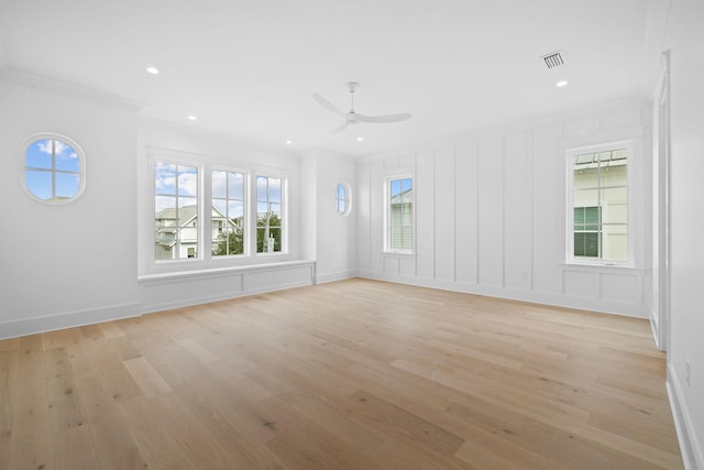 empty room with light wood-type flooring, ceiling fan, and crown molding