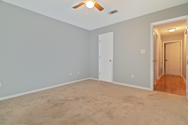 unfurnished room featuring light carpet and ceiling fan