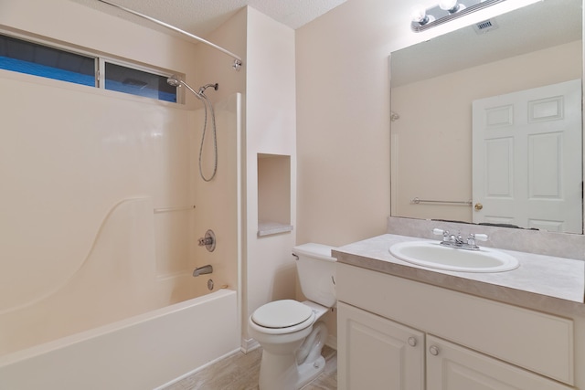 full bathroom with bathtub / shower combination, hardwood / wood-style flooring, vanity, toilet, and a textured ceiling