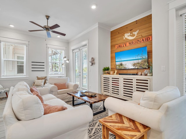 living room with ceiling fan, crown molding, and wooden walls