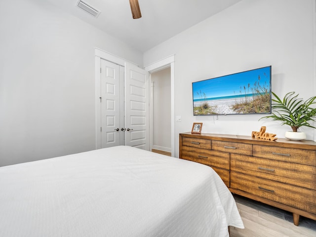 bedroom with light hardwood / wood-style flooring, a closet, and ceiling fan