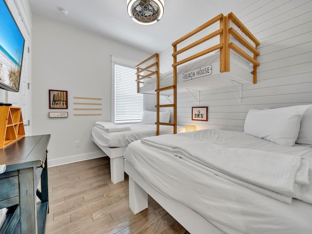 bedroom with hardwood / wood-style floors and wood walls