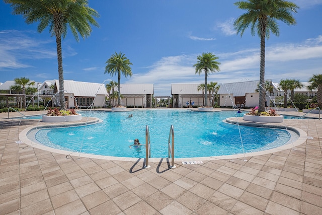 view of swimming pool featuring pool water feature and a patio