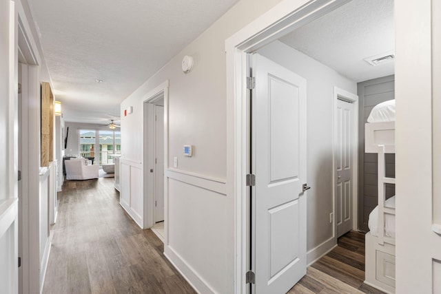 hallway featuring dark hardwood / wood-style floors and a textured ceiling