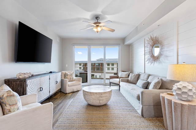 living room featuring ceiling fan and hardwood / wood-style floors