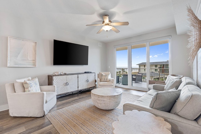 living room featuring ceiling fan and dark hardwood / wood-style floors