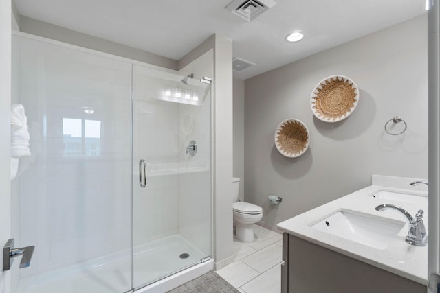 bathroom featuring tile patterned flooring, vanity, toilet, and a shower with shower door