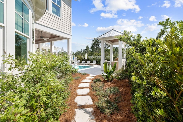 view of yard featuring a fenced in pool and ceiling fan