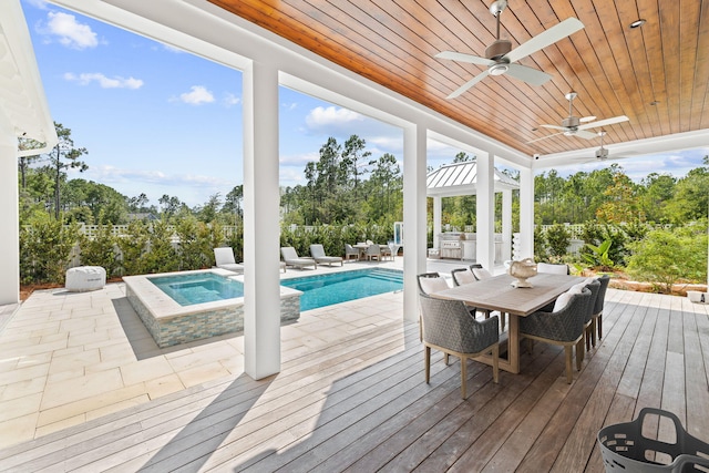 wooden terrace featuring ceiling fan and a swimming pool with hot tub