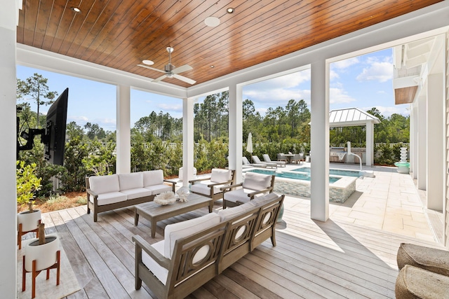 sunroom with ceiling fan and wood ceiling