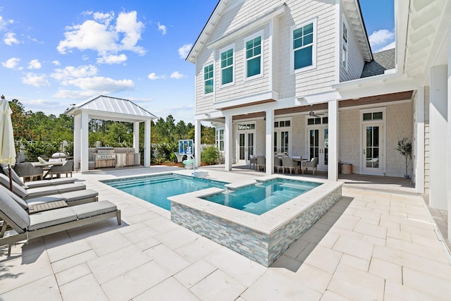 rear view of property with area for grilling, ceiling fan, a patio, and a swimming pool with hot tub