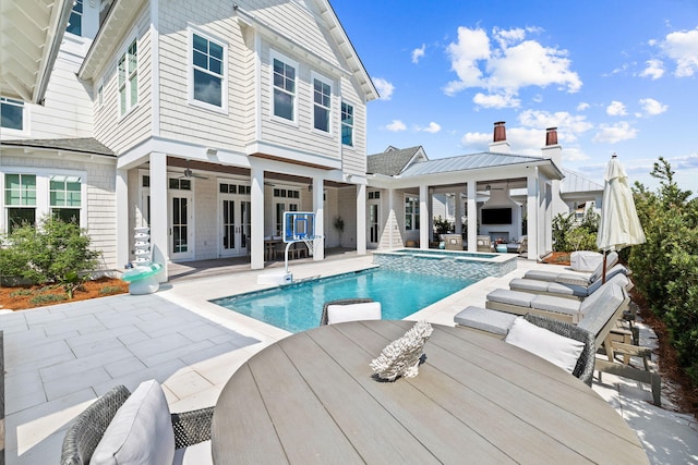 view of swimming pool with ceiling fan, an in ground hot tub, and a patio area