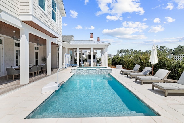 view of swimming pool with ceiling fan, a patio, and an in ground hot tub