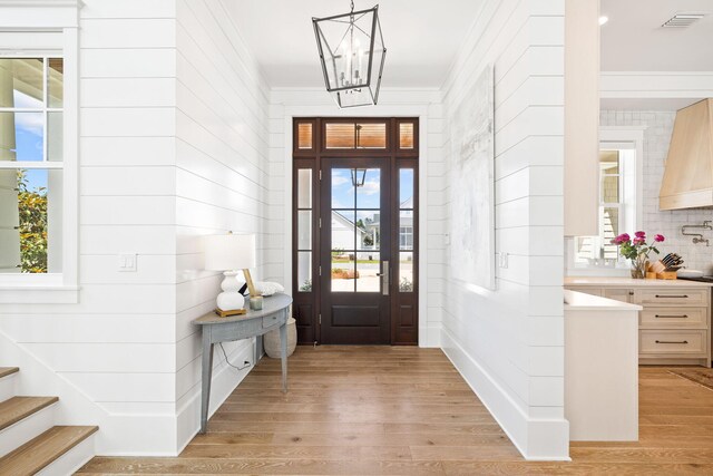 12 Needle Cast Ln, Inlet Beach, FL 32461 - entrance foyer with light wood-style flooring, a chandelier, and ornamental molding