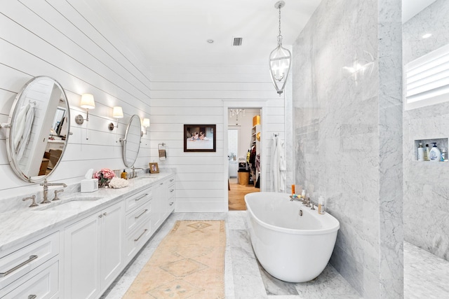 bathroom featuring wood walls, vanity, and a bath