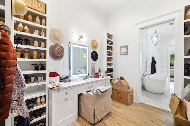 bathroom featuring a bath, hardwood / wood-style floors, vanity, and crown molding