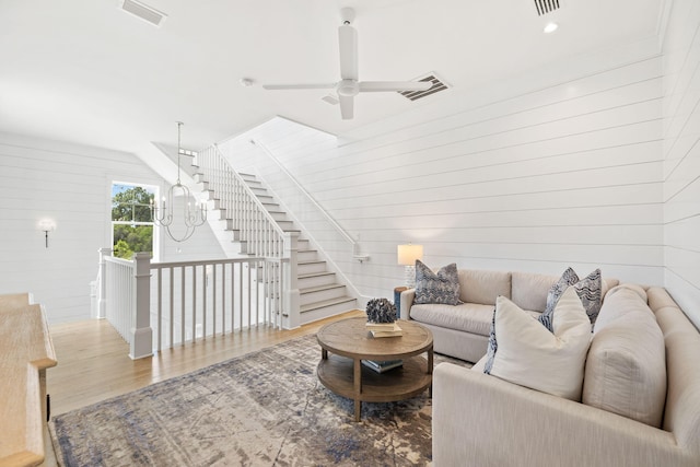 living room with wooden walls, ceiling fan, and hardwood / wood-style flooring