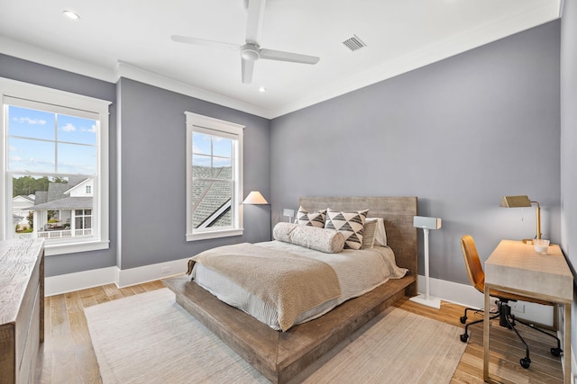 bedroom featuring ceiling fan, light hardwood / wood-style flooring, and crown molding