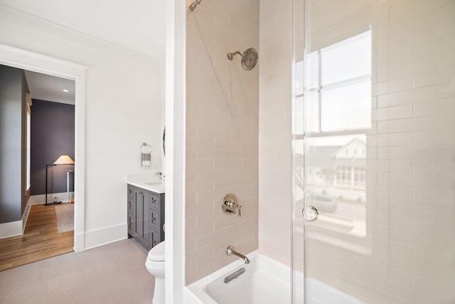 full bathroom with vanity, tiled shower / bath combo, crown molding, wood-type flooring, and toilet