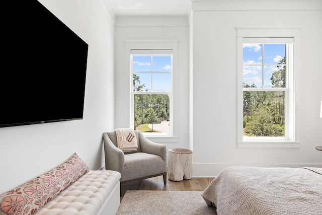 bedroom with multiple windows, crown molding, and light wood-type flooring