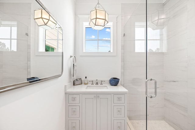 bathroom with walk in shower, vanity, and plenty of natural light