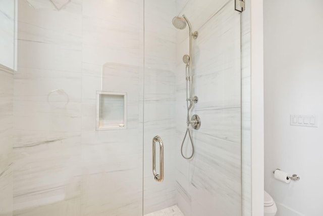 bathroom featuring an enclosed shower and toilet