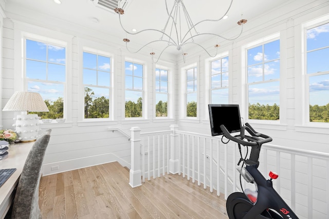 workout room with crown molding, light wood-type flooring, and plenty of natural light