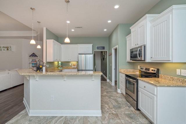 kitchen with kitchen peninsula, decorative light fixtures, stainless steel appliances, and white cabinetry