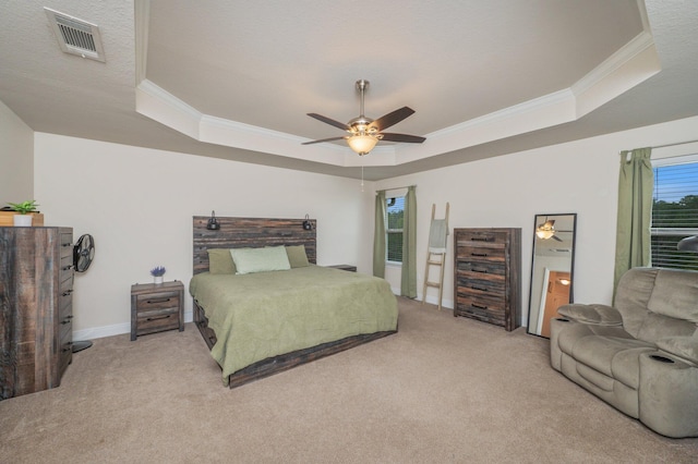 bedroom with ornamental molding, a tray ceiling, ceiling fan, and light colored carpet