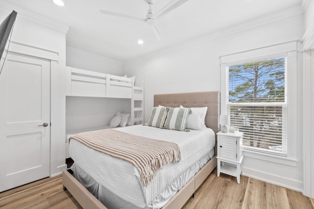 bedroom with ornamental molding, light wood-type flooring, and ceiling fan