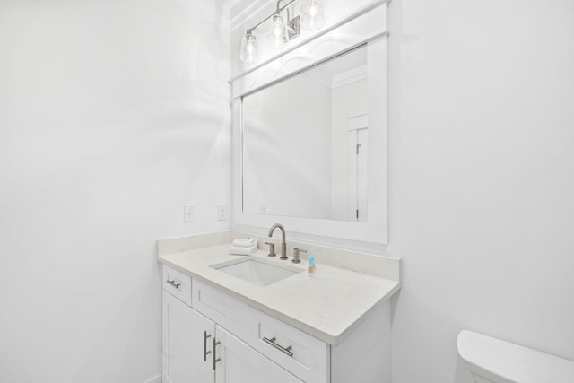 bathroom with vanity, toilet, and crown molding