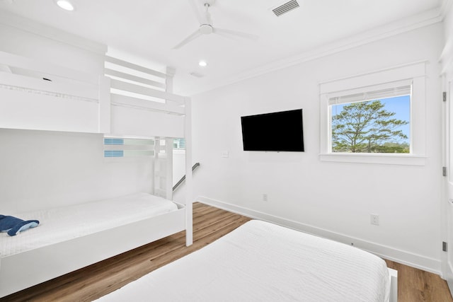 bedroom featuring ornamental molding, wood-type flooring, and ceiling fan