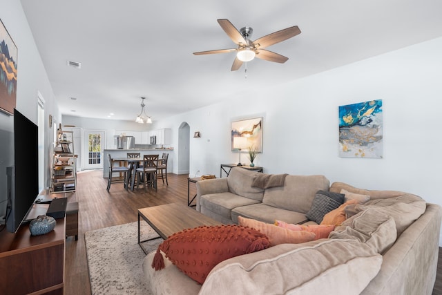 living room with dark wood-type flooring and ceiling fan