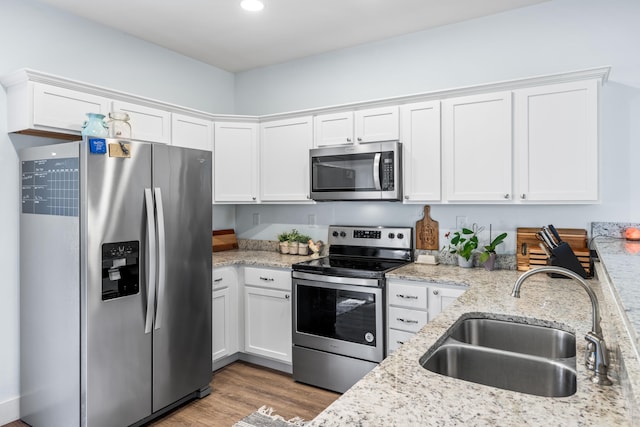 kitchen featuring sink, appliances with stainless steel finishes, light stone countertops, white cabinets, and dark hardwood / wood-style flooring