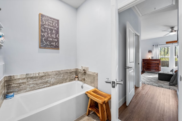 bathroom featuring hardwood / wood-style floors, ceiling fan, and a washtub