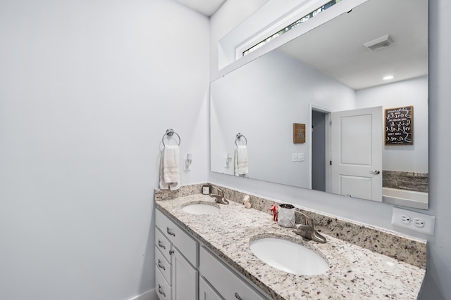 bathroom featuring double vanity, visible vents, and a sink