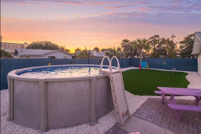 pool at dusk featuring a patio