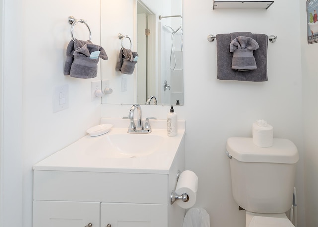 bathroom with a shower, vanity, and toilet