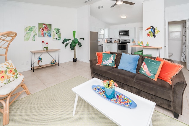 tiled living room with ceiling fan and vaulted ceiling