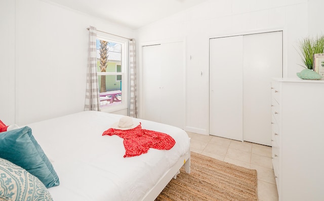 tiled bedroom with two closets and vaulted ceiling