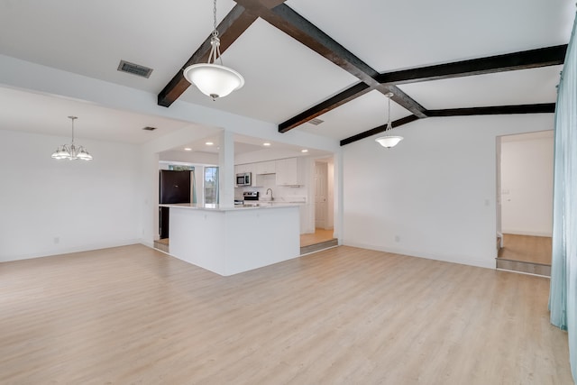 unfurnished living room with vaulted ceiling with beams, sink, a notable chandelier, and light wood-type flooring