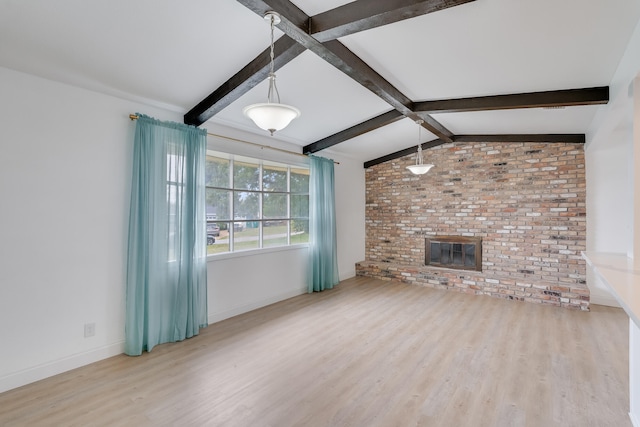 unfurnished living room with light wood-type flooring, lofted ceiling with beams, a brick fireplace, and brick wall