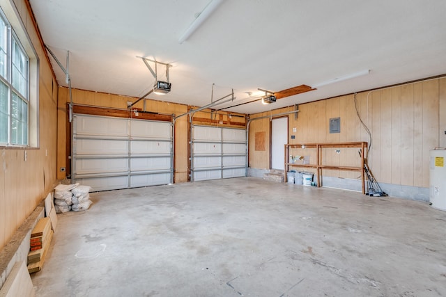 garage with water heater, a garage door opener, and wood walls