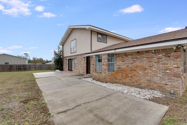 back of property featuring a yard and a patio area