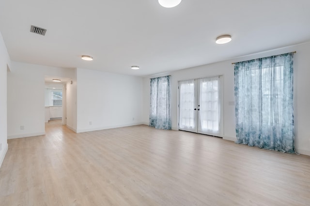 empty room with french doors and light wood-type flooring