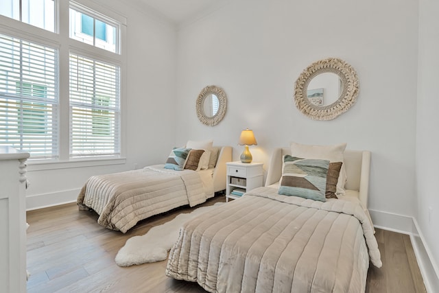 bedroom with wood-type flooring and crown molding